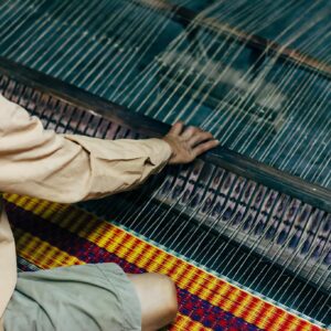 A craftsman weaving on a loom in Hội An, showcasing traditional textile production.