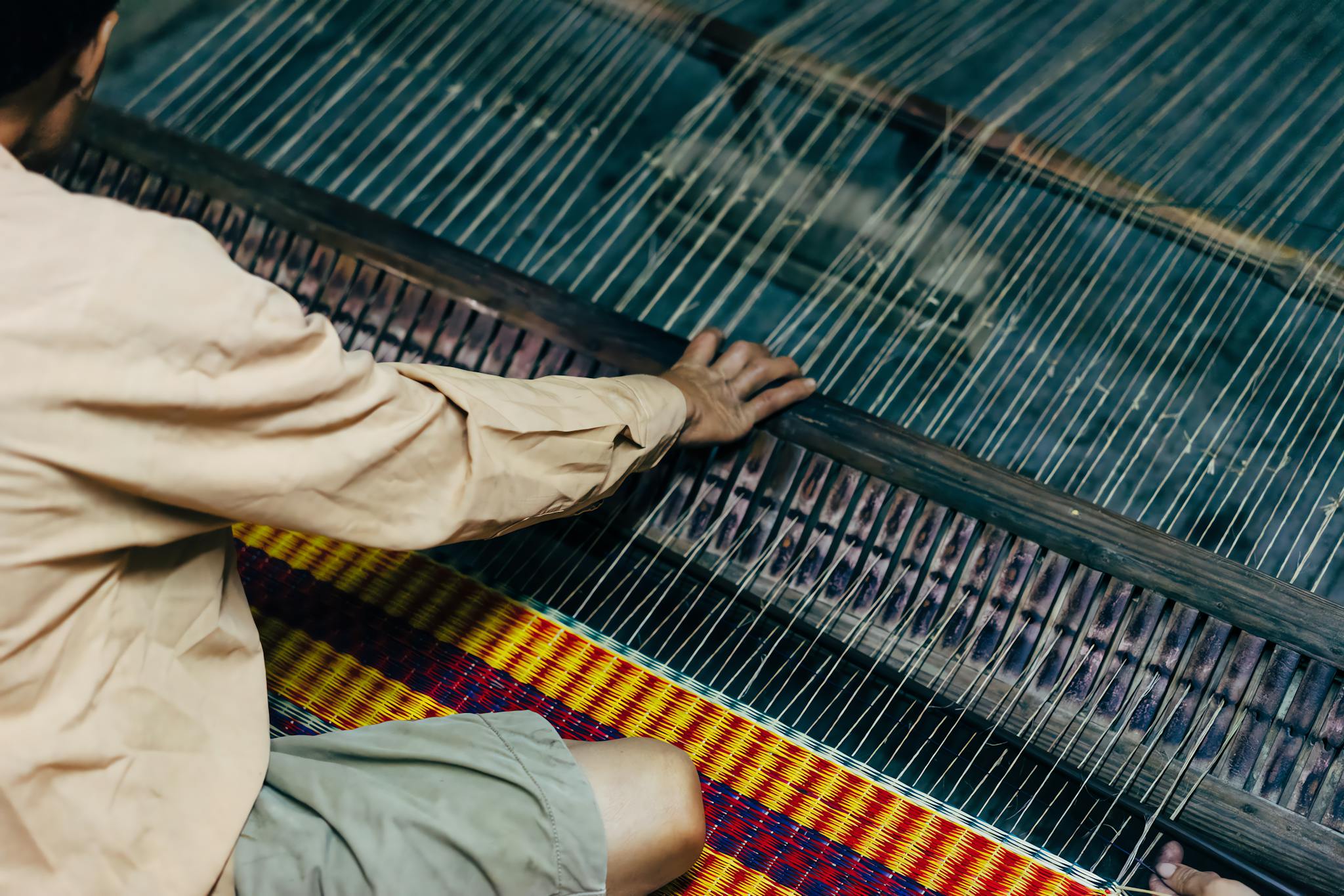 Home A Craftsman Weaving On A Loom In